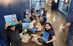 students holding up the new books